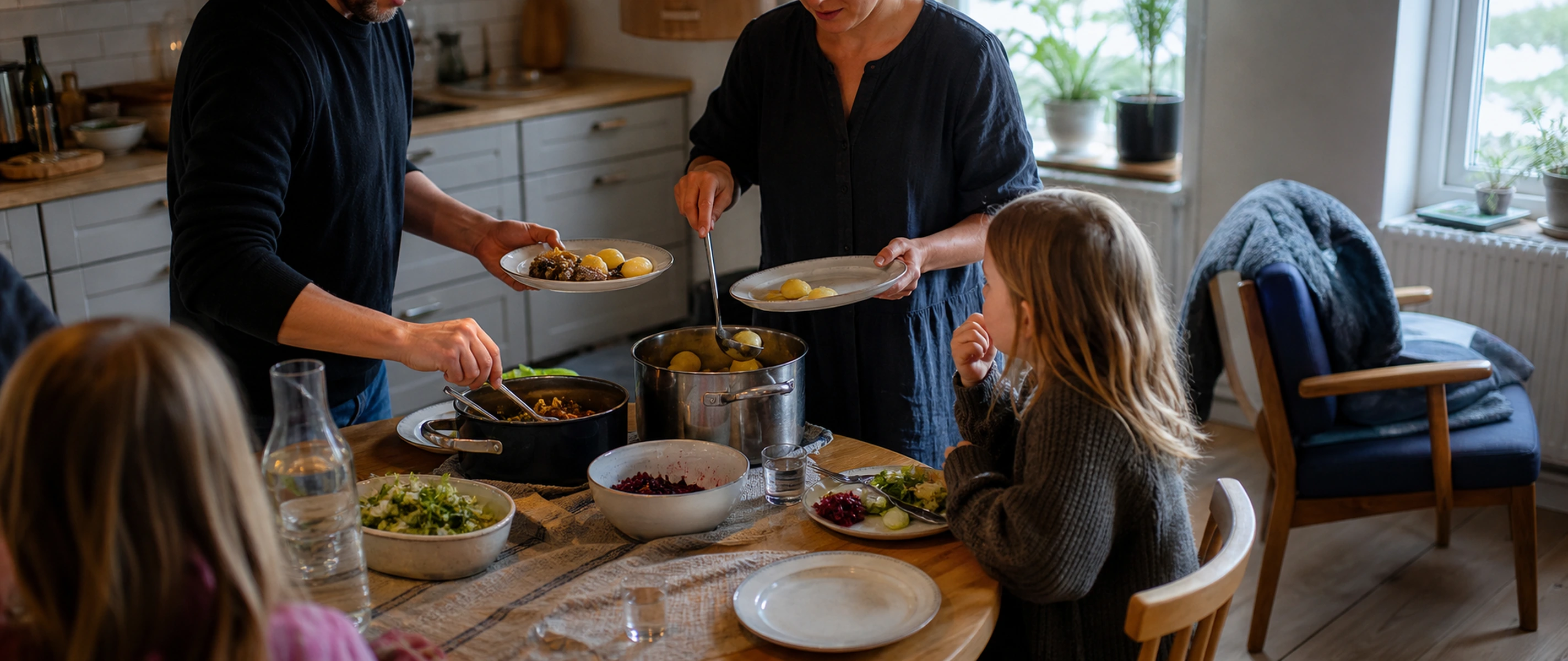 Människor som äter middag tillsammans i ett skandinaviskt kök en vardagskväll.